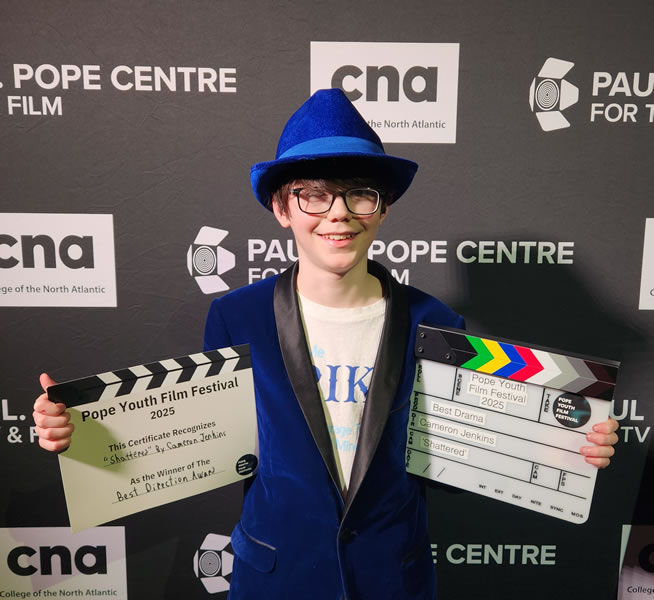 Photo of Cameron holding 2 awards from the 2025 Pope Youth Film Festival